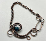 This Lovely Blue Apatite and Wire Wrapped Copper Wave Bracelet is a stunning piece of jewelry featuring vibrant blue apatite stones set against an intricate copper wave design. The bracelet combines the natural beauty of apatite with the elegance of wire-wrapped copper to create a unique and eye-catching accessory.