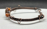This handcrafted bracelet features a harmonious blend of earthy Rainforest Jasper and vibrant Carnelian, wrapped in warm copper wire. The adjustable design ensures a comfortable fit, while the copper wirework enhances the natural beauty of the stones.