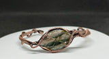 This cuff bracelet features a beautifully carved labradorite stone, known for its magical flashes of blue, green, and gold. The stone is securely wrapped in rich, handwoven copper wire, forming a bold and elegant cuff that radiates both strength and mystique.