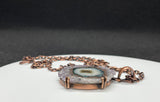 This Purple, Brown, Green, and White Stalactite Slice Necklace features a beautifully natural stalactite slice adorned with a variety of colors including purple, brown, green, and white, all set in copper. This necklace highlights the unique geological beauty of stalactites and the craftsmanship of copper jewelry.