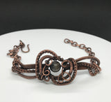 This Wire Wrapped Copper Bracelet with Agate is a stunning piece that beautifully marries the elegance of Agate with the intricate artistry of wire wrapping. Its adjustable design ensures a comfortable fit for various wrist sizes, making it a versatile and attractive addition to any jewelry collection.