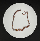 This delicate copper bracelet features an elegant wave design, accented with shimmering glass beads for a touch of color and sparkle. The bracelet is adjustable from 7 ½ to 9 inches, providing a comfortable fit, and can be shortened upon request. The warm tones of the copper combined with the playful, flowing wave design make this piece a versatile accessory for both casual and formal looks. Perfect for those who appreciate subtle elegance with a handcrafted touch.