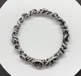 Crafted from over 6 feet of heavy-duty 8-gauge antiqued aluminum wire, this bold bangle bracelet features an intricate swirl design that’s both durable and lightweight. The antiqued finish adds depth and character.
