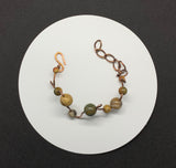 This unique bracelet is handcrafted from heavy gauge copper, shaped and curved into an organic freeform design. Accented with Picasso Jasper beads, known for their intricate natural patterns and earthy tones, The warm hues of the copper beautifully complement the stone’s striking marbled appearance. A bold statement bracelet for those who appreciate artisan craftsmanship and nature-inspired jewelry.