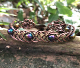 This unique 7" cuff bracelet features sturdy 18-gauge copper braided together with vibrant rainbow glass beads, creating a stunning contrast of warm metal and colorful accents. The intricate braid adds texture and depth, while the glass beads catch the light, adding a playful shimmer. Perfect for anyone who loves handcrafted, statement jewelry, this cuff is both bold and comfortable for everyday wear.
