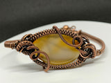This bracelet features a warm gradient of creamy yellow to rich brown agate, wrapped in handwoven copper for a rustic yet refined look. The adjustable copper fastener ensures a comfortable fit, while the natural variations in the agate make each piece completely unique. Earthy, versatile, and full of character — a timeless accessory for everyday wear.