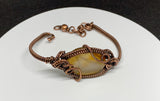 This bracelet features a warm gradient of creamy yellow to rich brown agate, wrapped in handwoven copper for a rustic yet refined look. The adjustable copper fastener ensures a comfortable fit, while the natural variations in the agate make each piece completely unique. Earthy, versatile, and full of character — a timeless accessory for everyday wear.