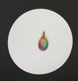 This pendant showcases a rainbow quartz cabochon, dyed in stunning pastel shades that shimmer softly in the light. The stone is gracefully encased in handwoven polished copper, adding warmth and intricate detail to the design. A perfect accessory for those who appreciate unique, handcrafted jewelry with a playful yet elegant touch.
