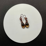 Copper embraces smoky quartz in these earrings, the stones glinting like twilight through mist. Niobium ear wires complete the design with a gentle, skin-friendly touch.