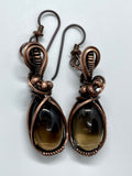 Copper embraces smoky quartz in these earrings, the stones glinting like twilight through mist. Niobium ear wires complete the design with a gentle, skin-friendly touch.