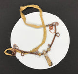 Embrace the elegance of nature and artistry with the Stunning Woven Copper Necklace. Featuring a striking combination of Picasso Jasper, copper beads, and a silk ribbon cord, this necklace is a unique statement piece that beautifully blends organic beauty with sophisticated design.