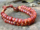 This adjustable bracelet is a stunning blend of vintage charm and contemporary craftsmanship. Featuring African trade beads, silk, and leather, this bracelet brings a touch of history and artistry to your wrist. The button closure ensures a secure fit and adds to the bracelet's unique design.