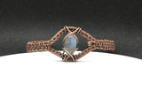 This adjustable bracelet showcases a mesmerizing marquise-shaped Labradorite cabochon, wrapped in warm, handwoven copper. The Labradorite's enchanting flashes of color catch the light beautifully, making this piece a standout addition to any jewelry collection. With its adjustable design, this bracelet ensures a comfortable fit while blending elegance with everyday wearability.