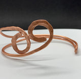 This striking bracelet is crafted from heavy gauge copper that has been expertly annealed and hammered, creating a unique texture that catches the light beautifully. The organic design showcases the rich warmth of copper, making it a standout piece in any jewelry collection. Comfortable and lightweight, this bracelet is a true testament to the beauty of handcrafted jewelry.