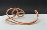 This striking bracelet is crafted from heavy gauge copper that has been expertly annealed and hammered, creating a unique texture that catches the light beautifully. The organic design showcases the rich warmth of copper, making it a standout piece in any jewelry collection. Comfortable and lightweight, this bracelet is a true testament to the beauty of handcrafted jewelry.