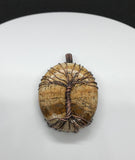 Embrace the natural beauty of the earth with the Picture Jasper Tree of Life Pendant in Copper. This stunning piece features a richly detailed picture jasper cabochon, intricately set within a handcrafted copper Tree of Life design. The pendant combines natural artistry with elegant craftsmanship, creating a timeless accessory.