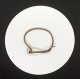 This standout bracelet features hammered brass waves, interwoven with intricate handwoven copper detailing. The combination of textures and warm metallic tones creates a unique and eye-catching piece that exudes both elegance and craftsmanship. Perfect for those who love bold, artisanal jewelry, this bracelet adds a touch of sophistication to any look.