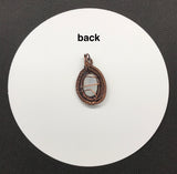This pendant features layers of intricately wire wrapped copper surrounding an iridescent rainbow moonstone. The combination of detailed copper wirework and the moonstone’s enchanting play of colors creates a visually stunning and sophisticated piece of jewelry.