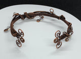 This eye-catching bracelet showcases a stunning combination of woven copper, intricate copper swirls, and shimmering iridescent glass bead dangles. The rich, warm tones of the copper beautifully complement the radiant beads, creating a unique artistic design. Handcrafted with care, this bracelet is perfect for those who love bold, statement jewelry with a touch of whimsical sparkle.