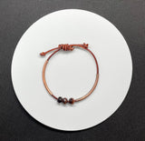 This handcrafted adjustable leather bracelet features rich faceted Tiger Eye, accented by warm copper tubes for a bold yet earthy design. The deep, chatoyant hues of the gemstone shimmer beautifully, while the supple leather ensures a comfortable fit. With its adjustable design, this bracelet is perfect for everyday wear, adding a touch of natural energy to any outfit.