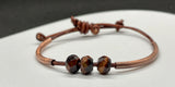 This handcrafted adjustable leather bracelet features rich faceted Tiger Eye, accented by warm copper tubes for a bold yet earthy design. The deep, chatoyant hues of the gemstone shimmer beautifully, while the supple leather ensures a comfortable fit. With its adjustable design, this bracelet is perfect for everyday wear, adding a touch of natural energy to any outfit.