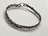 This bracelet features multiple strands of copper skillfully braided together, creating a rich texture and visual interest. Each strand has been hammered to enhance its natural shine and add a unique artisanal touch. The bracelet showcases the warm tones of copper, making it a versatile accessory for any occasion.
