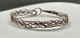 This bracelet features multiple strands of copper skillfully braided together, creating a rich texture and visual interest. Each strand has been hammered to enhance its natural shine and add a unique artisanal touch. The bracelet showcases the warm tones of copper, making it a versatile accessory for any occasion.