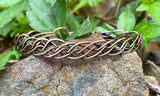 This bracelet features multiple strands of copper skillfully braided together, creating a rich texture and visual interest. Each strand has been hammered to enhance its natural shine and add a unique artisanal touch. The bracelet showcases the warm tones of copper, making it a versatile accessory for any occasion.