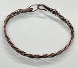 This bracelet features multiple strands of copper skillfully braided together, creating a rich texture and visual interest. Each strand has been hammered to enhance its natural shine and add a unique artisanal touch. The bracelet showcases the warm tones of copper, making it a versatile accessory for any occasion.