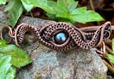 This handcrafted bracelet features a stunning peacock pearl at its center, radiating iridescent shades of deep blue, green, and violet. Surrounded by intricate handwoven copper weaves, the design blends elegance with earthy artistry. The warm copper tones perfectly complement the pearl’s luster, making this bracelet a unique and eye-catching addition to any jewelry collection.