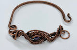 This handcrafted bracelet features a stunning peacock pearl at its center, radiating iridescent shades of deep blue, green, and violet. Surrounded by intricate handwoven copper weaves, the design blends elegance with earthy artistry. The warm copper tones perfectly complement the pearl’s luster, making this bracelet a unique and eye-catching addition to any jewelry collection.