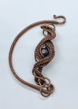 This handcrafted bracelet features a stunning peacock pearl at its center, radiating iridescent shades of deep blue, green, and violet. Surrounded by intricate handwoven copper weaves, the design blends elegance with earthy artistry. The warm copper tones perfectly complement the pearl’s luster, making this bracelet a unique and eye-catching addition to any jewelry collection.