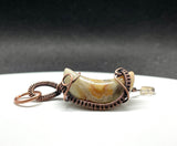 This Crazy Lace Agate Moon Pendant is a stunning piece of jewelry featuring a moon-shaped Crazy Lace Agate gemstone wrapped in copper wire with a Quartz star dangle. Known for its intricate patterns and vibrant colors, Crazy Lace Agate adds a unique and whimsical touch to this celestial-themed pendant. The addition of the Quartz star dangle enhances its charm and makes it a distinctive and elegant accessory.