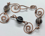This bracelet features hand-formed and hammered copper links, each uniquely crafted for a rustic yet refined appeal. Adorned with beautiful Botswana agate beads, known for their soothing gray and earthy tones, this bracelet combines elegance with natural charm. Perfect for everyday wear or as a statement accessory.