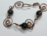 This bracelet features hand-formed and hammered copper links, each uniquely crafted for a rustic yet refined appeal. Adorned with beautiful Botswana agate beads, known for their soothing gray and earthy tones, this bracelet combines elegance with natural charm. Perfect for everyday wear or as a statement accessory.