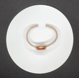 This beautiful bangle bracelet features a vibrant Carnelian stone intricately carved into a delicate flower, accentuating the stone’s natural warm hues. The flower is set on a handcrafted copper bangle, adding an earthy elegance and timeless charm. Perfect for nature lovers and those who appreciate artisanal jewelry, this bracelet makes a lovely statement piece with its warm colors and unique design.