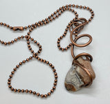 This bold, one-of-a-kind necklace features a tumbled Crazy Lace Agate, securely embraced by hammered and hand-formed heavy gauge copper. The natural swirls and banding of the agate are beautifully contrasted by the rugged texture and warm tone of the copper. A powerful statement of organic design and artisan craftsmanship—earthy, eye-catching, and full of character.
