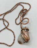 This bold, one-of-a-kind necklace features a tumbled Crazy Lace Agate, securely embraced by hammered and hand-formed heavy gauge copper. The natural swirls and banding of the agate are beautifully contrasted by the rugged texture and warm tone of the copper. A powerful statement of organic design and artisan craftsmanship—earthy, eye-catching, and full of character.