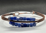 This bracelet features square-cut blue Sodalite beads, known for their rich, deep hues and natural patterns. The copper wirework creates a beautiful contract and enhances the bracelet's elegance while maintaining its rustic charm.