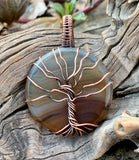 This Lightweight Striped Agate Tree of Life Pendant is a striking and elegant piece of jewelry that combines the natural beauty of striped agate with the timeless symbolism of the Tree of Life. Crafted in copper, this pendant offers a blend of modern and classic styles, making it a versatile addition to any jewelry collection.