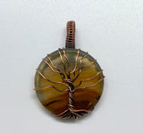 This Lightweight Striped Agate Tree of Life Pendant is a striking and elegant piece of jewelry that combines the natural beauty of striped agate with the timeless symbolism of the Tree of Life. Crafted in copper, this pendant offers a blend of modern and classic styles, making it a versatile addition to any jewelry collection.