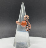 This sparkling adjustable ring features a radiant Goldstone, known for its deep coppery glow and subtle shimmer. Wire wrapped Copper and the warm tones of both stone and metal create a rich, earthy elegance. The adjustable band ensures a comfortable fit.