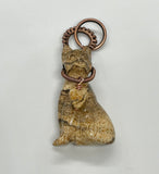 A carved picture jasper cat pendant wrapped in copper wire — earthy, graceful, and full of quiet personality. A perfect piece for cat lovers who see beauty in nature’s details.
