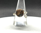 This unique ring showcases a stunning Venus Jasper gemstone, meticulously wrapped in high-quality Argentium silver wire for a sleek and contemporary design. The adjustable nature of the band allows it to fit comfortably for sizes 9 and up, making it perfect for a variety of hand sizes. Venus Jasper, known for its grounding properties and beautiful earthy tones, creates a striking contrast against the bright, tarnish-resistant Argentium silver.