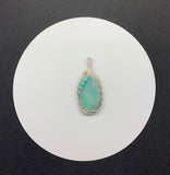 A beautiful Quartz pendant with silicated Chrysocolla inclusions and Turquoise accent beads in wire wrapped Sterling (.925) and Fine (.999) Silver.