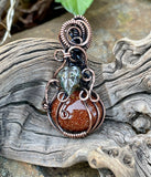 Embrace the essence of autumn with this enchanting swirling Goldstone pumpkin pendant, beautifully wrapped in warm copper. The shimmering hues of the Goldstone reflect the colors of fall, while a delicate glass leaf accent adds a playful touch. This unique pendant is perfect for celebrating the season, making it an ideal accessory for fall festivities or a thoughtful gift for nature lovers. Add a touch of seasonal charm to your jewelry collection with this delightful piece!