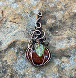 Embrace the spirit of fall with this charming swirling Goldstone pumpkin pendant, beautifully wrapped in warm copper. The rich, shimmering tones of the Goldstone capture the essence of autumn, while a delicate glass leaf accent adds a playful touch. This unique pendant is perfect for celebrating the season, making it an ideal accessory for fall festivities or a thoughtful gift for nature lovers. Add a touch of seasonal elegance to your collection with this delightful piece!