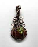 Embrace the spirit of fall with this charming swirling Goldstone pumpkin pendant, beautifully wrapped in warm copper. The rich, shimmering tones of the Goldstone capture the essence of autumn, while a delicate glass leaf accent adds a playful touch. This unique pendant is perfect for celebrating the season, making it an ideal accessory for fall festivities or a thoughtful gift for nature lovers. Add a touch of seasonal elegance to your collection with this delightful piece!