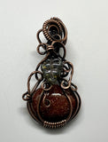 Embrace the essence of autumn with this enchanting swirling Goldstone pumpkin pendant, beautifully wrapped in warm copper. The shimmering hues of the Goldstone reflect the colors of fall, while a delicate glass leaf accent adds a playful touch. This unique pendant is perfect for celebrating the season, making it an ideal accessory for fall festivities or a thoughtful gift for nature lovers. Add a touch of seasonal charm to your jewelry collection with this delightful piece!