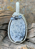 This Burro Creek Agate Pendant is a stunning and unique piece of jewelry, featuring a rare Burro Creek Agate stone with natural dendritic formations resembling trees. Wrapped in high-quality sterling silver (.925) and fine silver (.999), this pendant combines nature’s artistry with expert craftsmanship. The addition of Czech glass accent beads further enhances its beauty, making this pendant a timeless and eye-catching piece.